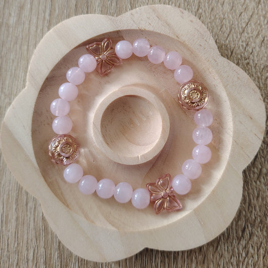 bracelet de perles rosées orné de papillon